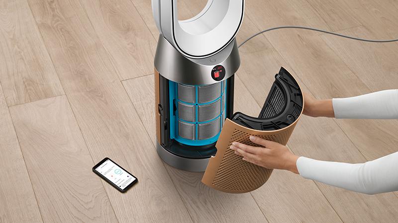 Một người đang tháo phần vỏ máy lọc không khí để thay bộ lọc.